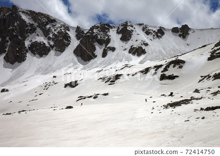 High mountains with snow cornice and avalanche trail High mountains with snow cornice and avalanche trail 72414750