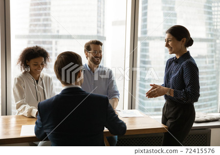 Indian female boss lead meeting with diverse colleagues 72415576
