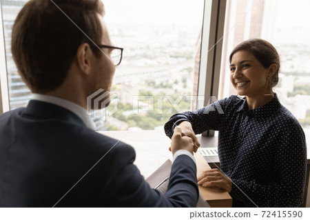 Male employer handshake ethnic female candidate at meeting 72415590