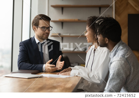 Male realtor consult biracial family at meeting 72415652