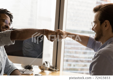 Happy multiethnic male friends give fist bump Happy multiethnic male friends give fist bump 72415653