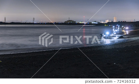 At the mouth of the Tenryu River in Iwata City, Shizuoka Prefecture, fishermen scoop up the beach with a net, relying on lighting. 72416312