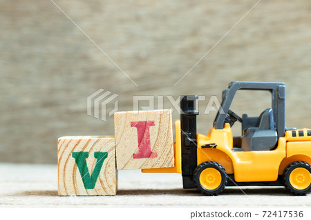 Toy forklift hold letter block to complete word VI (abbreviation for value investor) on wood background Toy forklift hold letter block to complete word VI (abbreviation for value investor) on wood background 72417536
