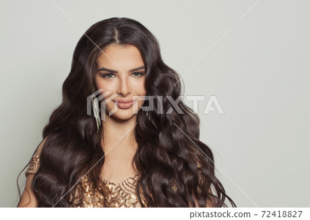 Smiling brunette woman with long healthy curly hairstyle portrait Smiling brunette woman with long healthy curly hairstyle portrait 72418827