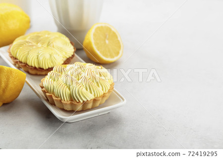 Tartlets with lemon cream on a white table. Tartlets with lemon cream on a white table. 72419295