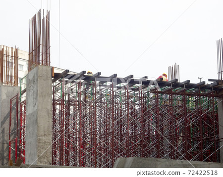 MALACCA, MALAYSIA -MARCH 2, 2020: Construction workers working at height at the construction site. They are supplied with harnesses and other safety equipment to prevent them from having an accident. 72422518