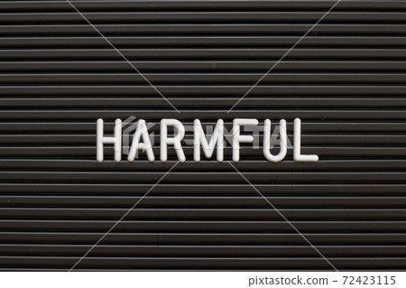 White alphabet in word harmful on black color felt letter board background 72423115
