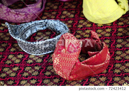 Traditional tengkolok also known as destar, setanjak or tanjak, and setangan kepala, It is a traditional Malay male headgear. It is made from long songket cloth folded and tied in particular style. Traditional tengkolok also known as destar, setanjak or tanjak, and setangan kepala, It is a traditional Malay male headgear. It is made from long songket cloth folded and tied in particular style. 72423412