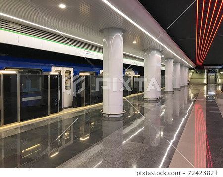 Nearly empty urban metro station with departing train 72423821