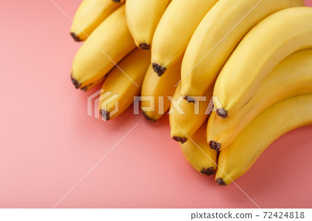 A bunch of ripe Yellow Bananas on a Pink Background. A bunch of ripe Yellow Bananas on a Pink Background. 72424818