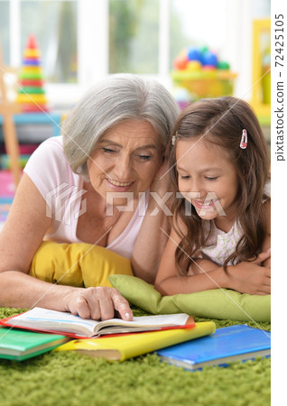 Grandmother reading book with her little granddaughter Grandmother reading book with her little granddaughter 72425105