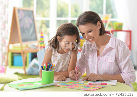 Cute girl with mother drawing at home 72425132
