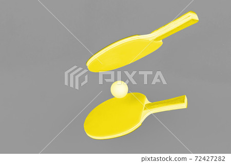 Illuminating yellow ping pong rackets on Ultimate Gray background Illuminating yellow ping pong rackets on Ultimate Gray background 72427282
