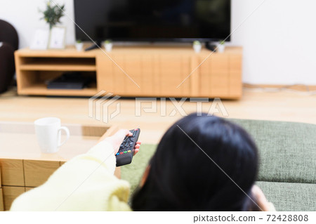 Woman watching TV in the living room 72428808