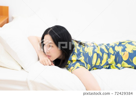 Woman lying on bed Woman lying on bed 72429384