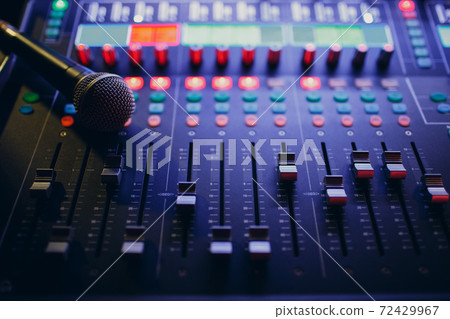 Mixing console and microphone, hand equalizing audio sound channels in night club Mixing console and microphone, hand equalizing audio sound channels in night club 72429967