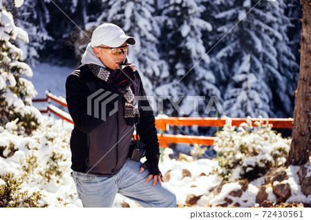 man relax in winter mountains and drinks tea 72430561