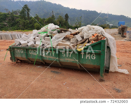 KUALA LUMPUR, MALAYSIA -MARCH 13, 2020: Huge wasted disposal bin used to collect rubbish and unused material from the construction site. Has a fixed collection schedule KUALA LUMPUR, MALAYSIA -MARCH 13, 2020: Huge wasted disposal bin used to collect rubbish and unused material from the construction site. Has a fixed collection schedule 72432003