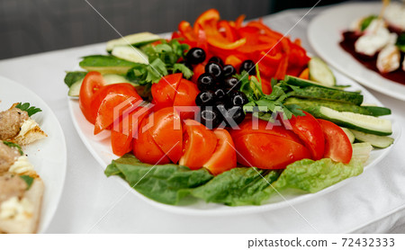 vegetable plate with tomato cucumbers olives and red pepper  72432333