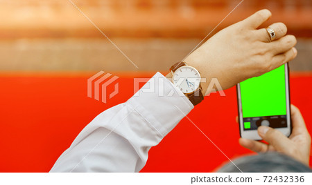 Man's hands shooting with phone empty green screen red carpet  72432336