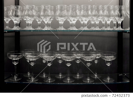 empty clean wine glasses on a glass shelf  72432373
