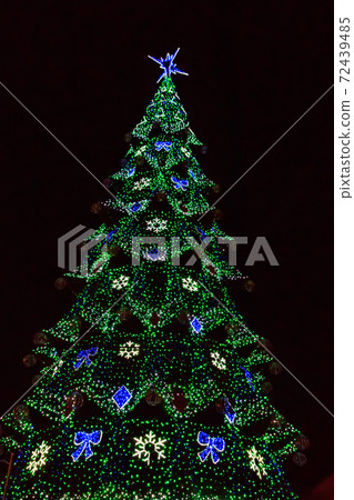 Decorated Christmas tree with multi-colored lights at night Decorated Christmas tree with multi-colored lights at night 72439485
