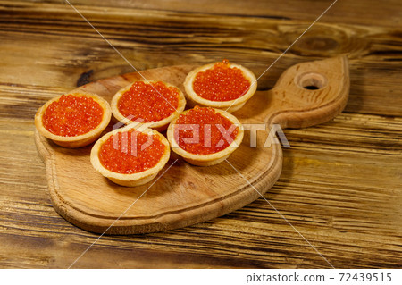Tartlets with red caviar on a wooden table 72439515
