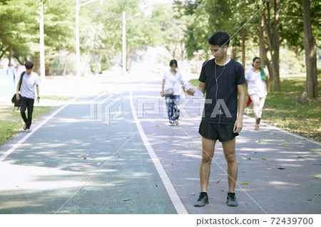 A man standing for a break from exercise A man standing for a break from exercise 72439700