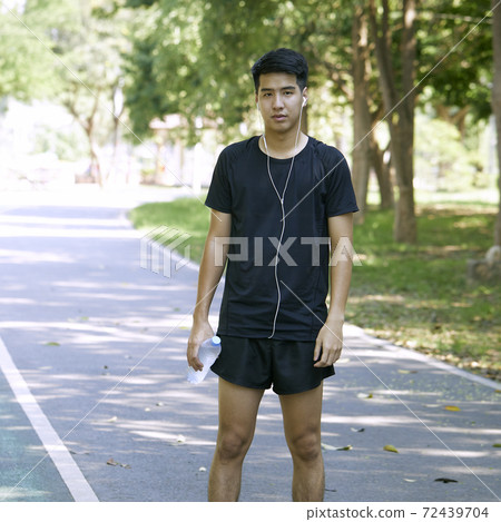 A man standing for a break from exercise A man standing for a break from exercise 72439704