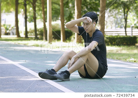 man sitting and exercising in the park 72439734