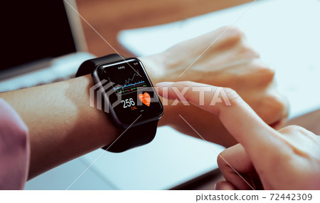 Close up of hand touching smartwatch with health app on the screen. 72442309