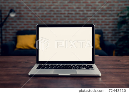 Laptop a blank screen on the table at night for putting on a computer advertisement. Laptop a blank screen on the table at night for putting on a computer advertisement. 72442310