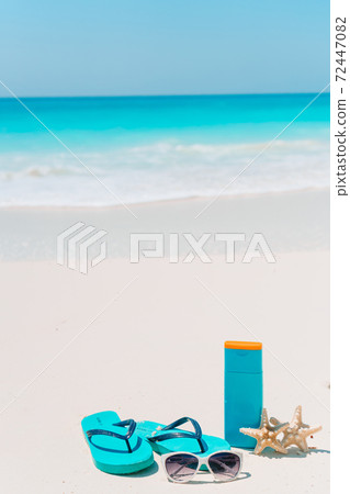 Suncream bottles, goggles, starfish and sunglasses on white sand beach background ocean Suncream bottles, goggles, starfish and sunglasses on white sand beach background ocean 72447082