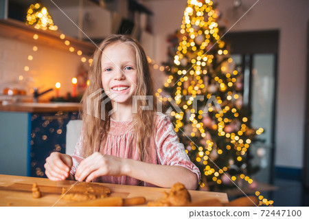 Adorable little girl baking Christmas gingerbread cookies Adorable little girl baking Christmas gingerbread cookies 72447100