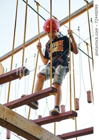 Boy walking on the ropes in a rope park 72448099