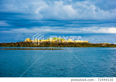 Small rocky islands on the horizon in the archipelago of Iles de Chausey. Brittany, France. 72449130
