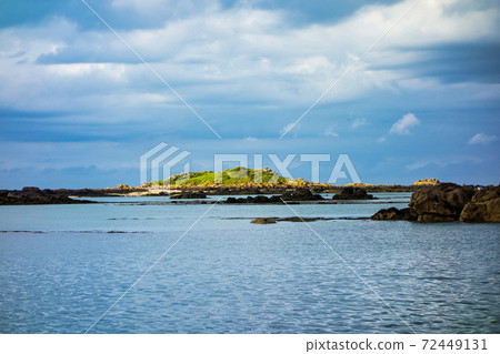 Small rocky islands on the horizon in the archipelago of Iles de Chausey. Brittany, France. 72449131