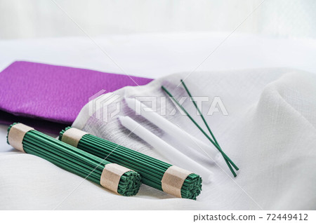 A bunch of incense sticks and candles 72449412