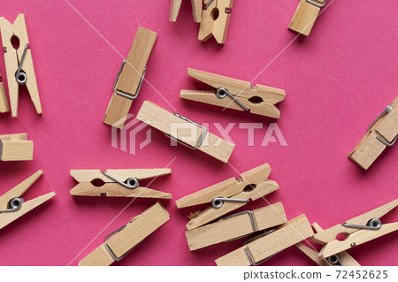 Many wooden clothespin on pink background. 72452625