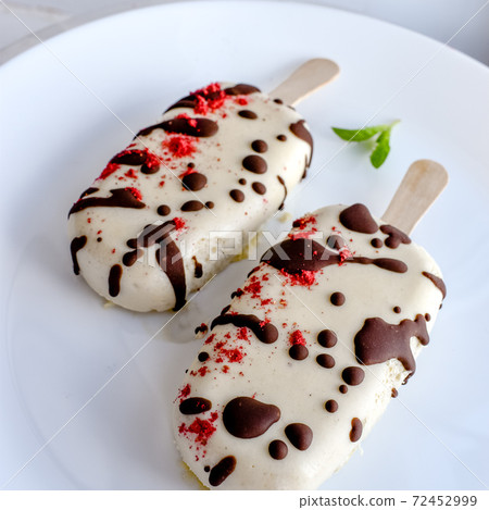 Ice cream sweet eskimo with chocolate icing. Homemade natural organic frozen vanilla dessert. Close up tasty treat popsicle photo 72452999
