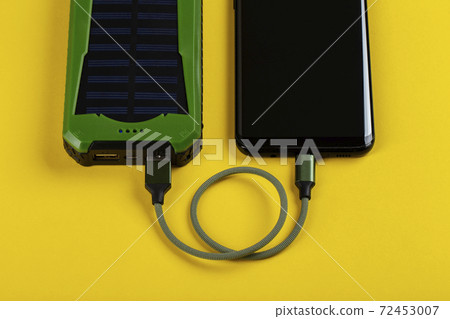 Smartphone Charging with Power Bank on Yelloy Background. 72453007