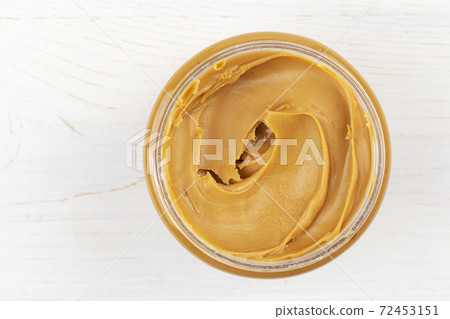 Jar of peanut butter on white wooden table. Space for text. Jar of peanut butter on white wooden table. Space for text. 72453151