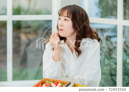 Woman eating Shine Muscat on the terrace 72453550