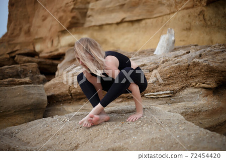 young beautiful woman meditates by the sea young beautiful woman meditates by the sea 72454420
