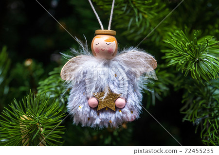 Russia. Saint-Petersburg. Christmas tree decoration little angel made of feathers with a star in his hands. Russia. Saint-Petersburg. Christmas tree decoration little angel made of feathers with a star in his hands. 72455235