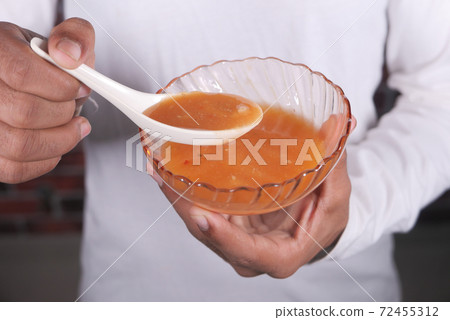 close up of man's hand eating thai hot spicy soup close up of man's hand eating thai hot spicy soup 72455312