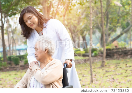 Doctor help and care Asian senior or elderly old lady woman patient sitting on wheelchair at park in nursing hospital ward 72455880