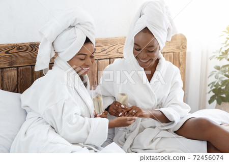 Pretty woman showing her engagement ring, sharing happiness with girlfriend Pretty woman showing her engagement ring, sharing happiness with girlfriend 72456074
