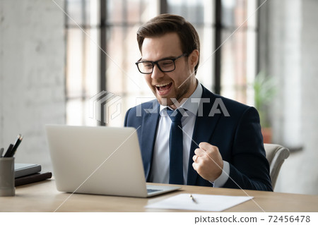 Close up overjoyed businessman wearing glasses excited by good news 72456478