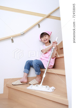 A 5-year-old girl helping with cleaning with a quick wiper A 5-year-old girl helping with cleaning with a quick wiper 72458045